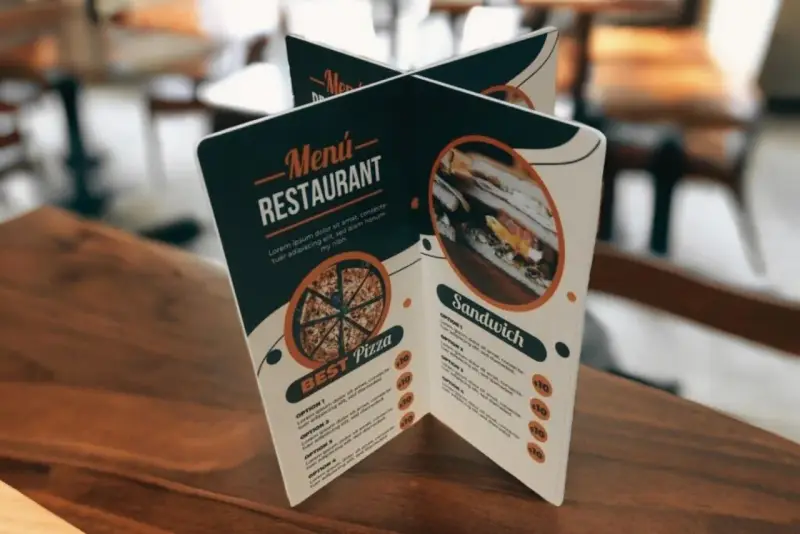 Carta de un restaurante con imágenes de pizza y sándwich. Muestra opciones de menú y precios.
